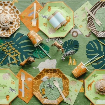 Conjunto de festa infantil com pratos, copos, guardanapos e decorações com tema de animais da selva