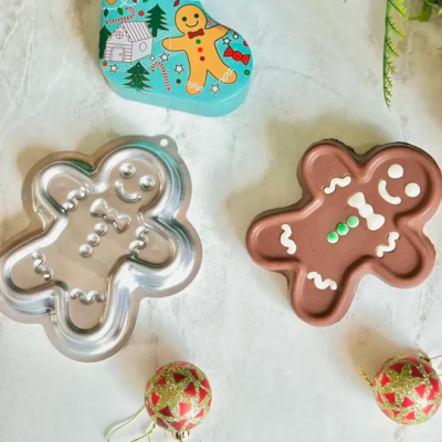 Forma e bolo em formato de biscoito de gengibre com decoração natalícia