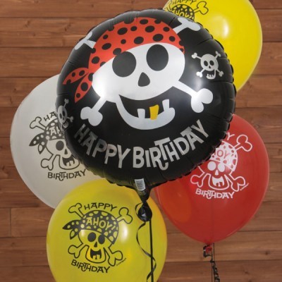 Balões de festa coloridos com desenhos de caveira e ossos cruzados e texto comemorativo.