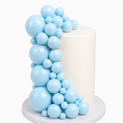 Bolo branco cilíndrico com bolas azuis brilhantes decorativas