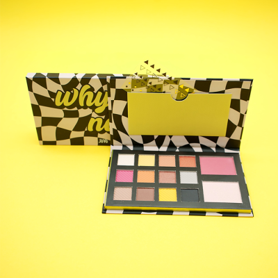 Paleta de maquilhagem com sombras e blushes, caixa xadrez preto e branco, fundo amarelo.