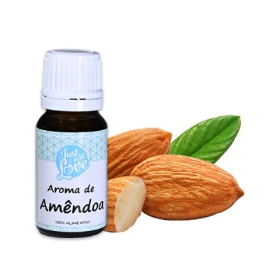 Garrafa de aroma de amêndoa com amêndoas e folha verde