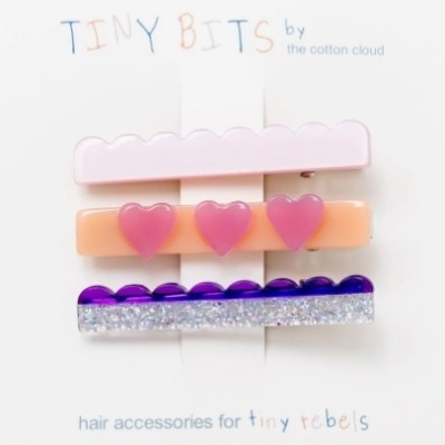 Três ganchos de cabelo coloridos em cartão com texto da marca