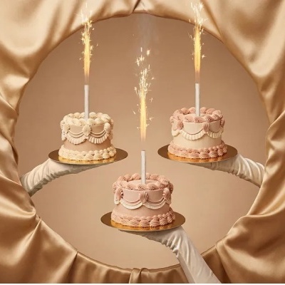 Três pequenos bolos decorados com velas acesas em fundo dourado elegante