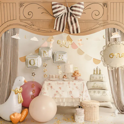 Decoração festa de aniversário com balões, cortinas às riscas e boneco inflável de ganso