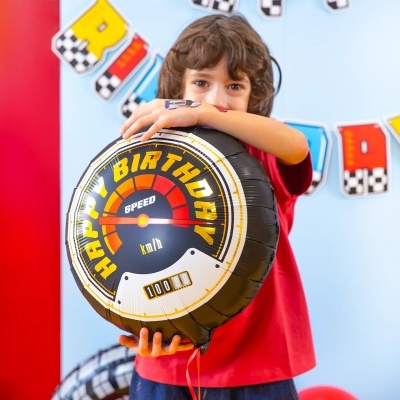 Balão de aniversário com design de velocímetro, criança segurando.