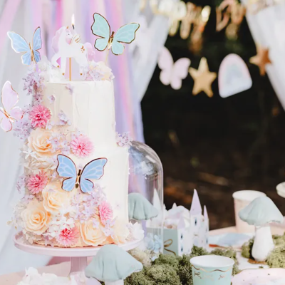 Bolo decorado com flores e borboletas em festa com doces