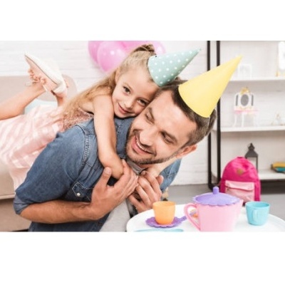 Criança e homem em festa com chapéus coloridos e brinquedos de chá