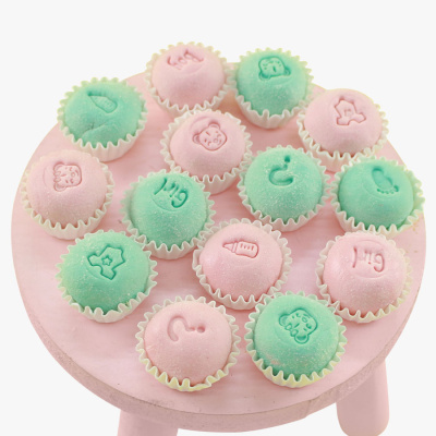 Bolinhos rosa e verde com desenhos infantis em suporte rosa