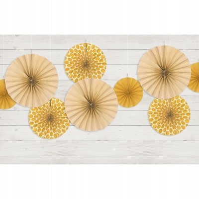 Decoração de parede com leques de papel amarelos e beiges sobre fundo de madeira clara