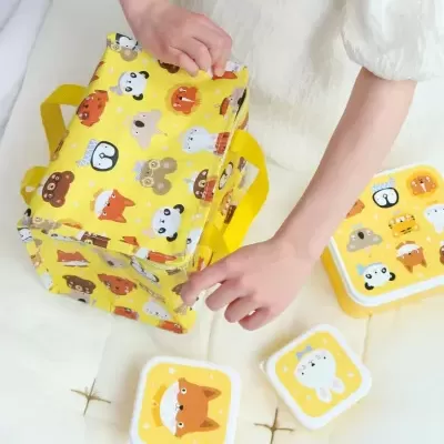 Bolsa térmica amarela com animais e caixas de lanche com desenhos de animais.