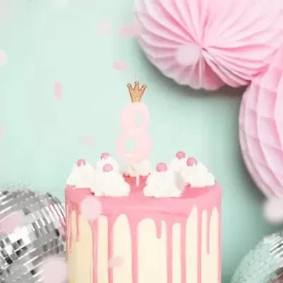 Bolo rosa e branco com vela número 8 e decoração festiva azul e rosa