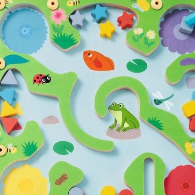 Peças de madeira coloridas com figuras de rã, peixe e insetos numa base azul claro