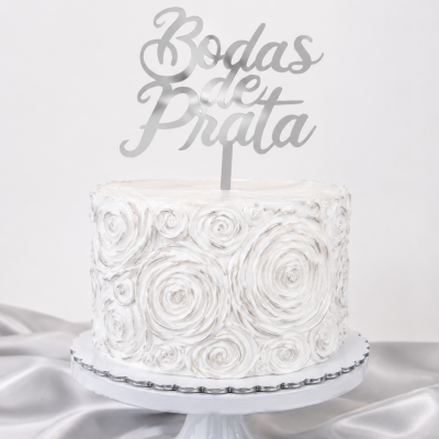Bolo branco decorado com flores em espiral e topo prateado com texto Bodas de Prata