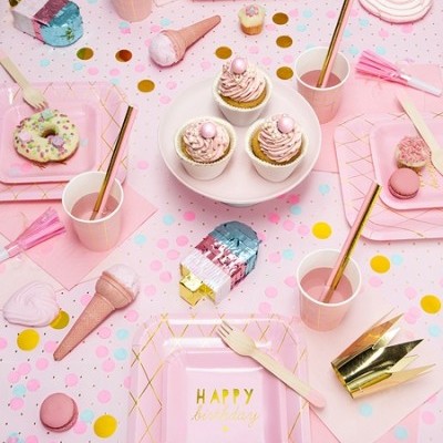 Mesa decorada para festa com artigos em tons de rosa, cupcakes, donuts, bolachas e confetes coloridos