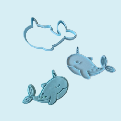 Moldes azuis em formato de narval sobre fundo azul claro