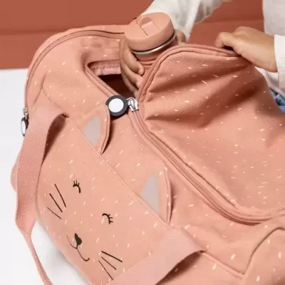 Mala cor de salmão com desenho de gato e garrafa colocada por criança