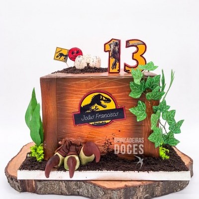 Bolo quadrado decorado com tema de dinossauros e números 13 no topo