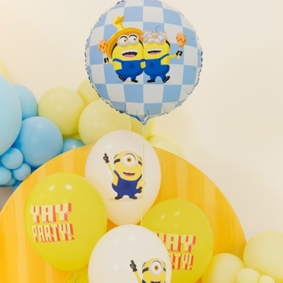 Balões temáticos de festa Minions em amarelo, branco e azul com textos YAY PARTY!! e imagens dos personagens.