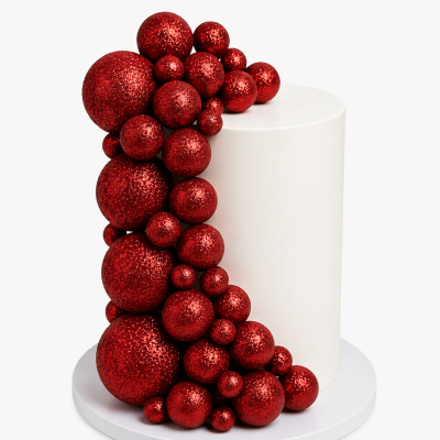 Bolo branco decorado com bolas vermelhas brilhantes em vários tamanhos