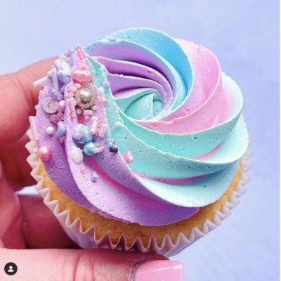 Cupcake com cobertura colorida em tons pastel e decoração de pérolas