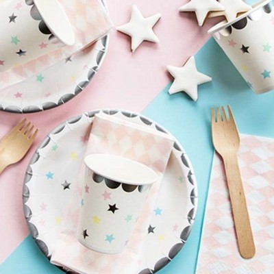 Conjunto de artigos para festa com estrelas coloridas e talheres de madeira sobre fundo rosa e azul.