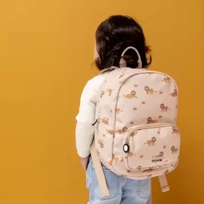 Mochila bege com padrão de leões usada por criança de costas