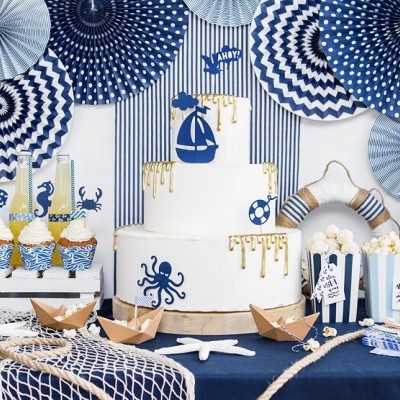 Mesa decorada com bolo e cupcakes em tema marinho azul e branco