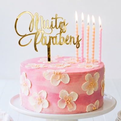 Bolo rosa decorado com flores e topo de bolo dourado Muitos Parabéns