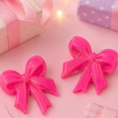 Dois laços decorativos rosa em plástico com caixas de presentes em tons pastel ao fundo