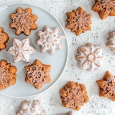 Bolachas em forma de flocos de neve com cobertura de gelo branco e açúcar em pó