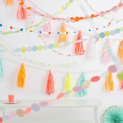 Decorações de festa coloridas penduradas numa parede branca