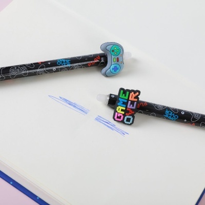 Dois lápis pretos com borrachas temáticas de videojogos sobre papel branco com riscos azuis.