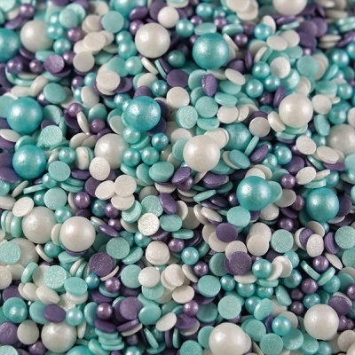 Confetes comestíveis coloridos em azul, lilás e branco com esferas e círculos.