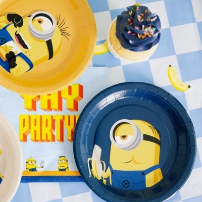 Pratos e guardanapo dos Minions com cupcake sobre toalha xadrez azul e branco