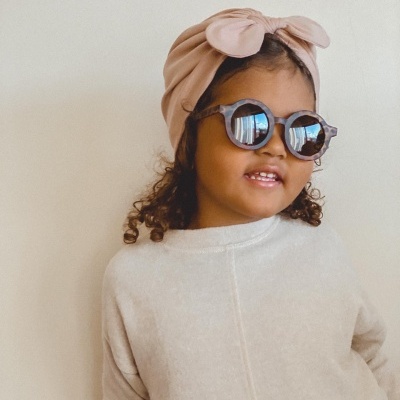 Criança com turbante rosa e óculos de sol posando