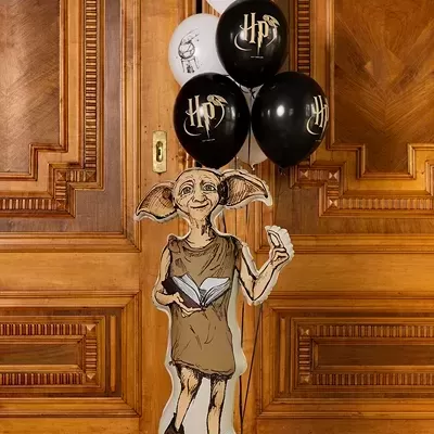 Figura insuflável de Dobby com balões de Harry Potter em frente a portas de madeira