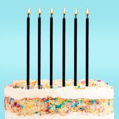 Bolo colorido com velas pretas acesas