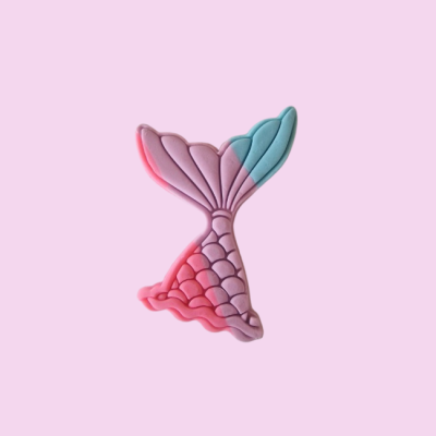 Figura decorativa cauda de sereia rosa e azul sobre fundo rosa claro