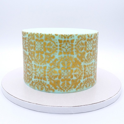 Bolo redondo com padrão dourado sobre azul claro em base branca