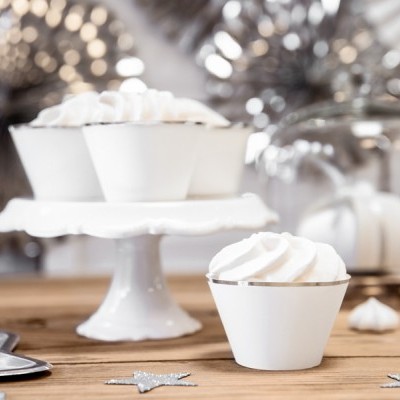 Tartes ou cupcakes brancos com cobertura de creme em suporte branco e mesa de madeira