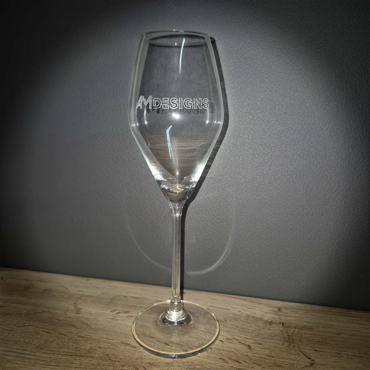 Brinde Empresarial – Copo Flute Premium Personalizado Copo de vidro transparente com texto AMDESIGNS gravado