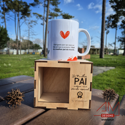 Caneca branca com coração vermelho e texto em português em cima de caixa de madeira com texto e logótipo AM DESIGNS ao ar livre