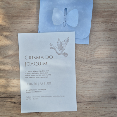 Convite de crisma com envelope azul sobre mesa de madeira