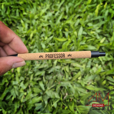 Caneta castanha com texto 'ABC PROFESSOR ABC' e fundo de relva verde.