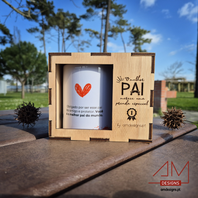 Caneca branca com coração laranja e texto, em caixa de madeira gravada, ao ar livre