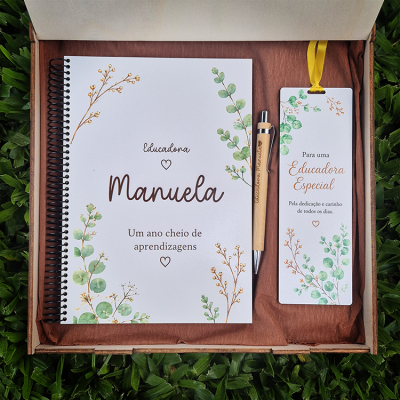 Conjunto de caderno, caneta e marcador decorados com flores verdes e castanhas numa caixa de presente