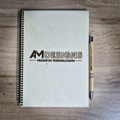 Bloco de notas branco em espiral com caneta AMDESIGNS sobre mesa de madeira