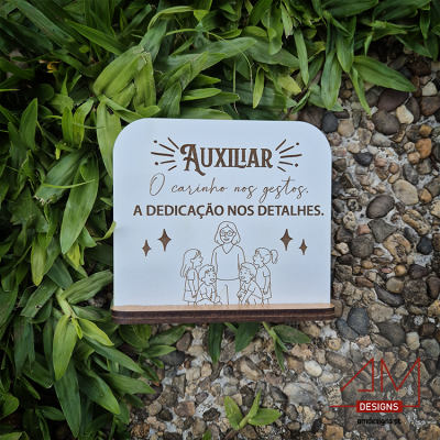 Suporte branco com texto e desenho sobre folhas verdes e pedras