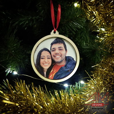 Enfeite de Natal redondo com foto personalizada de um casal numa árvore de Natal decorada